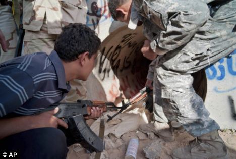 Revolutionary Libyan fighters inspect a storm drain where Muammar Gaddafi was found wounded in Sirte, Libya, last year